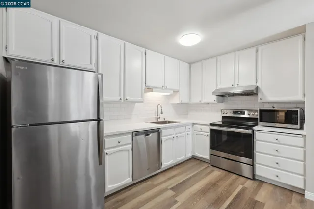 a kitchen with stainless steel appliances granite countertop a refrigerator sink and stove