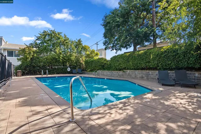 a view of a swimming pool with a patio and a yard