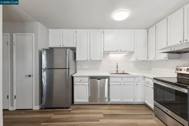 a kitchen with a refrigerator sink and cabinets