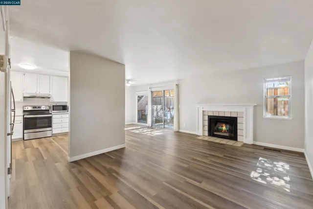 a view of empty room with wooden floor and fireplace