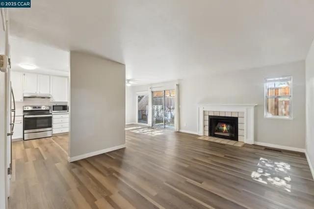 a view of empty room with wooden floor and fireplace
