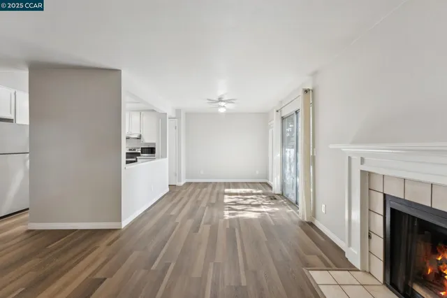 a view of a livingroom with wooden floor and a kitchen
