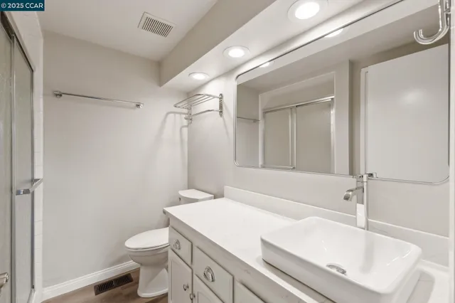 a bathroom with a sink a toilet and shower