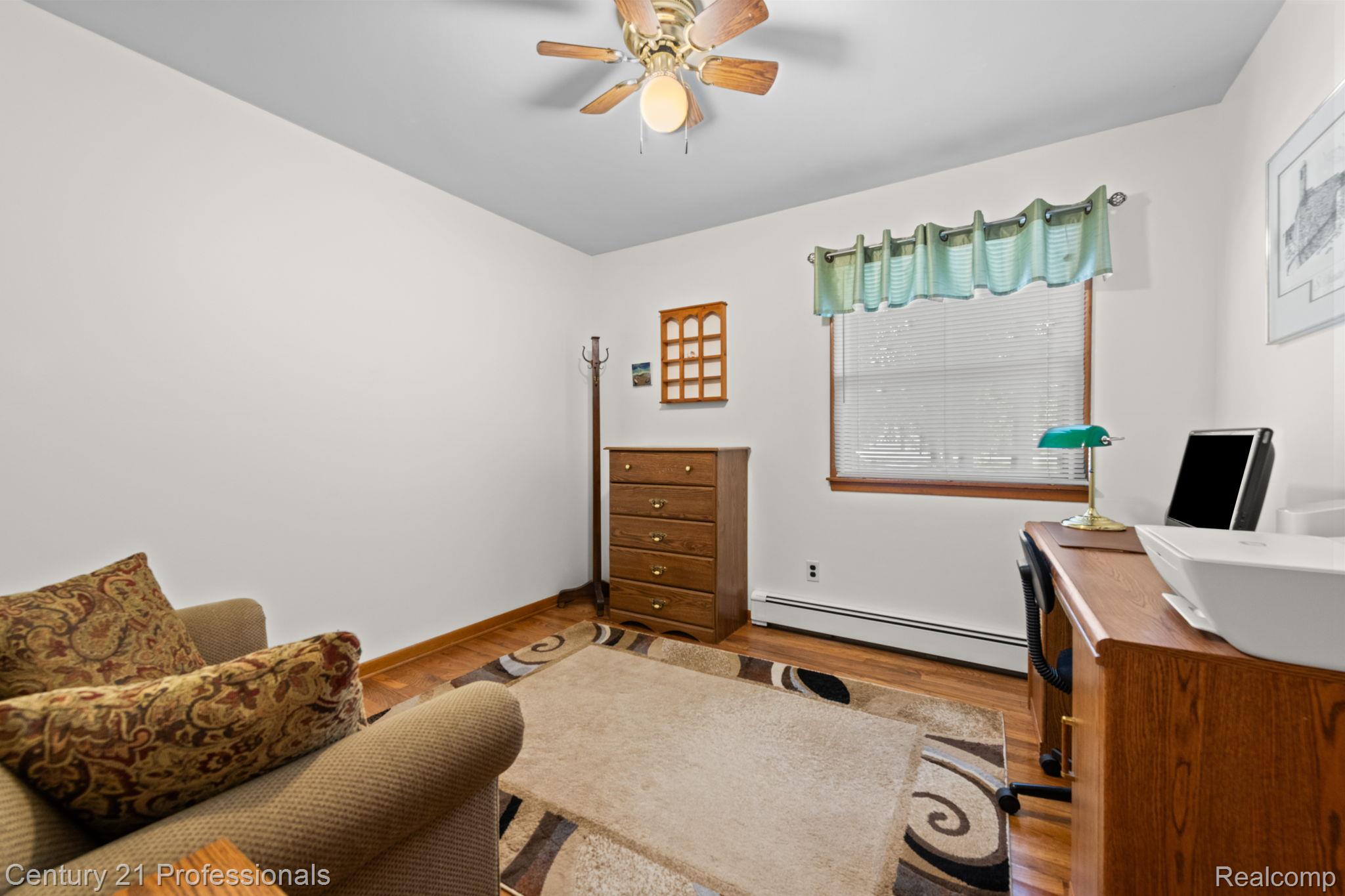 8638 Stone Road Algonac, MI 48001 - Photo 14 of 70 Home office featuring baseboard heating, wood finished floors, and a ceiling fan