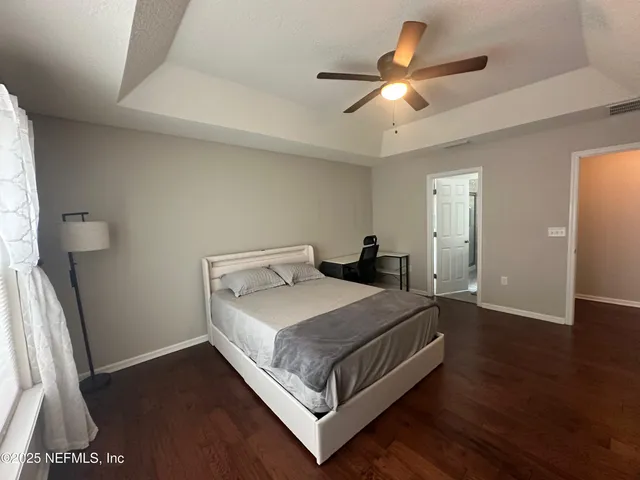 a bedroom with a bed and a large mirror