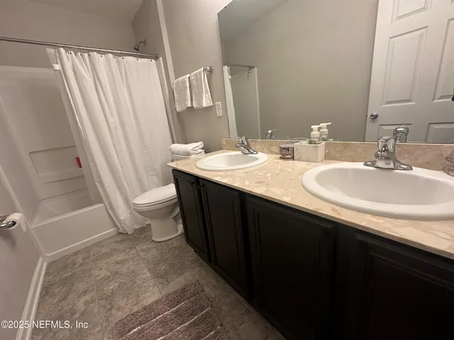 a bathroom with a double vanity sink and a mirror