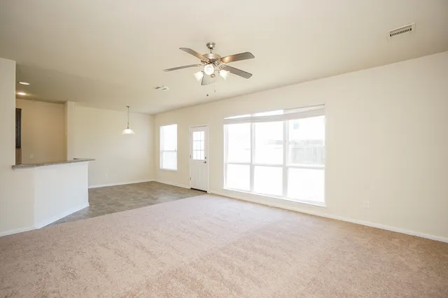 a view of a livingroom with a ceiling fan and window