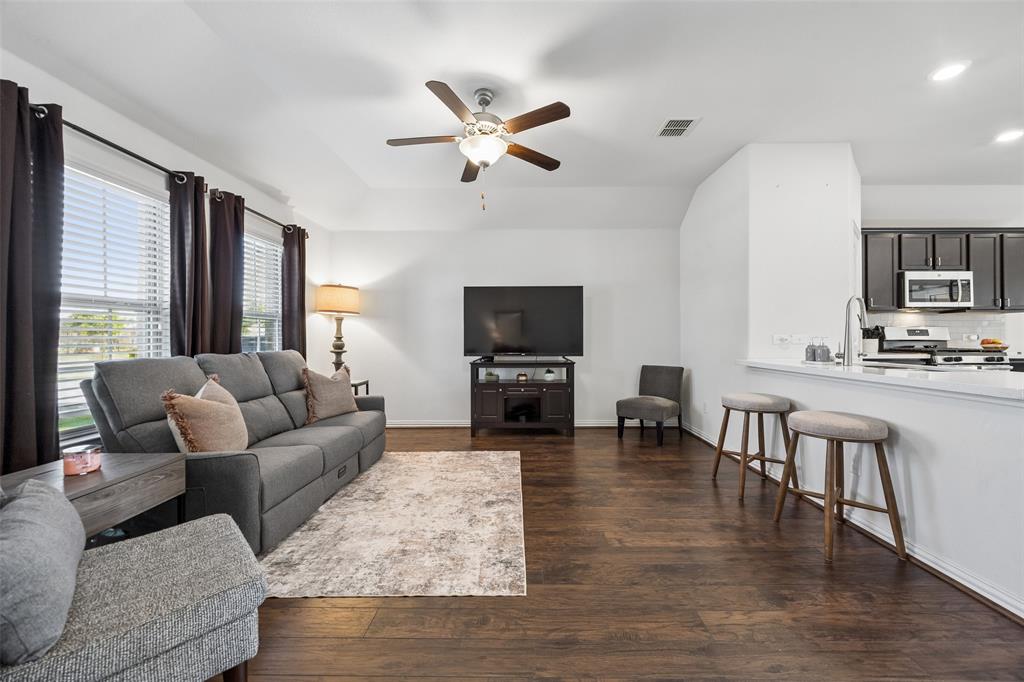 406 Madrone Lane Princeton, TX 75407 - Photo 5 of 30 Spacious living area featuring wood-finish flooring, a ceiling fan, and ample natural light from multiple windows