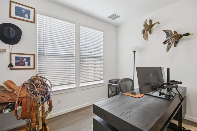 a view of a workspace with furniture and a window