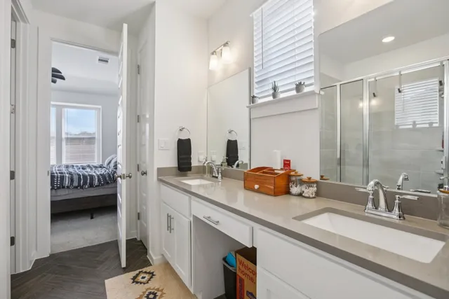 a bathroom with a double vanity sink a mirror and a shower
