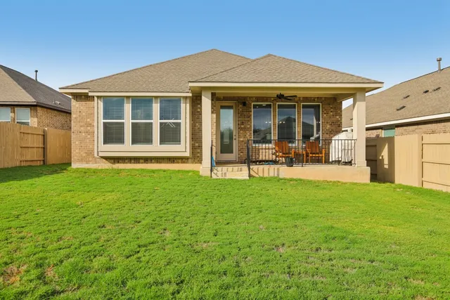 a front view of a house with a garden and chairs