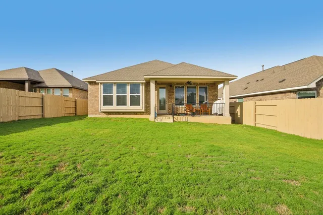 a view of a house with backyard and porch