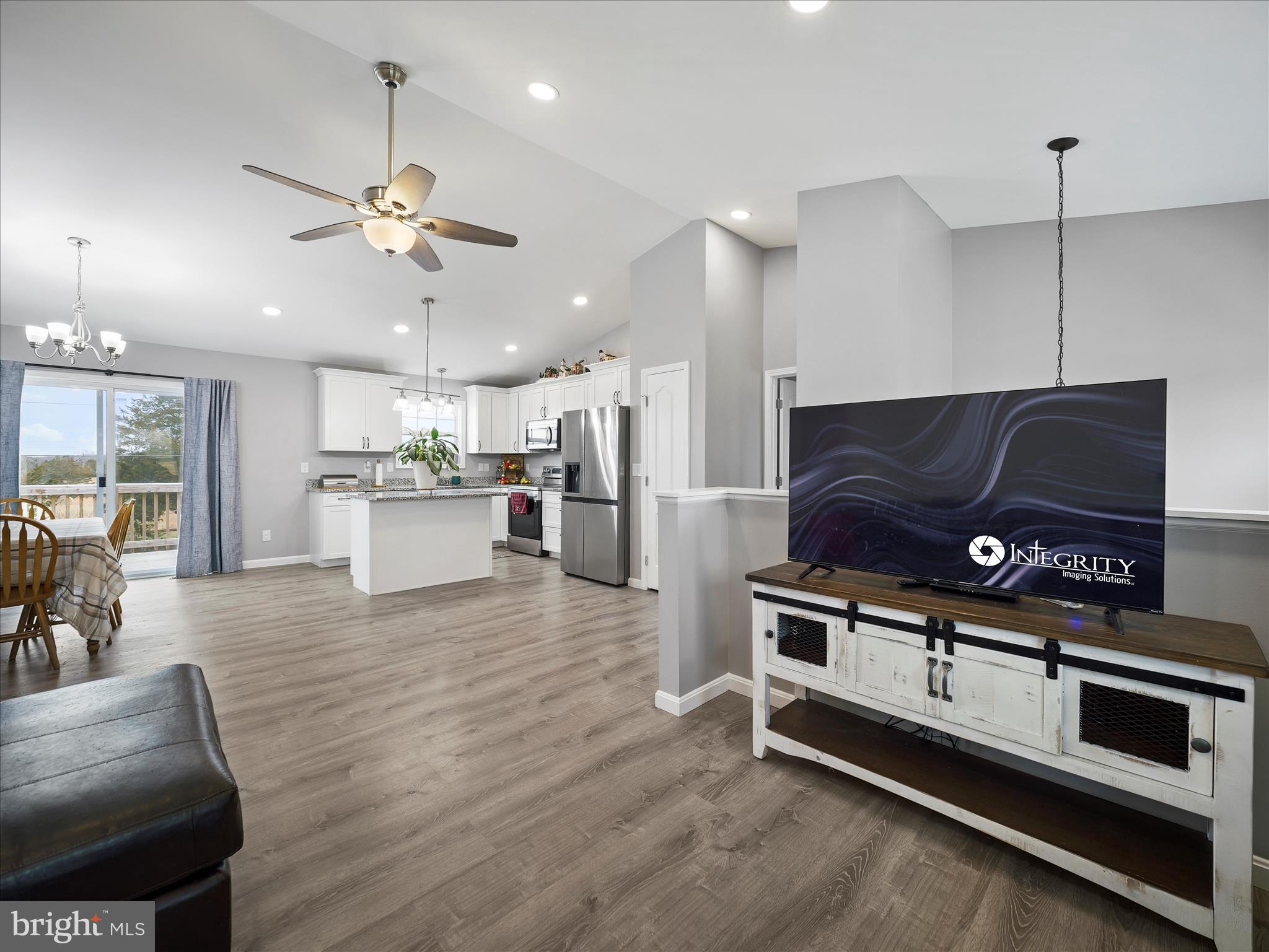 1885 Giles Mill Road Inwood, WV 25428 - Photo 26 of 40 a kitchen with stainless steel appliances kitchen island granite countertop a stove a refrigerator a fireplace a dining table and chairs with wooden floor