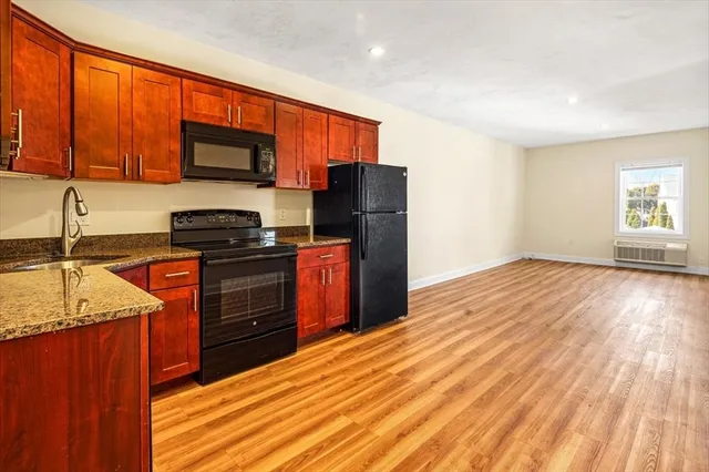 a kitchen with stainless steel appliances granite countertop a refrigerator sink and stove