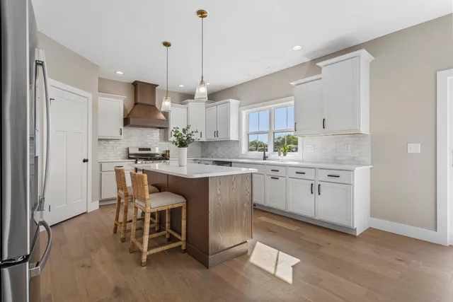 a kitchen with kitchen island granite countertop a sink a center island stainless steel appliances and cabinets