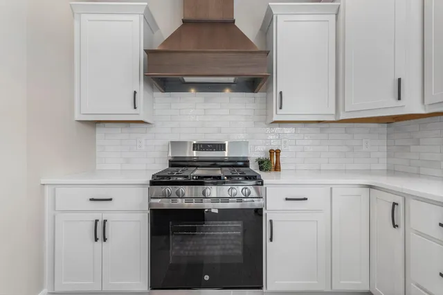 a kitchen with white cabinets and appliances