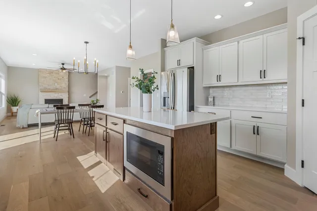 a kitchen with stainless steel appliances a stove a sink island and a wooden cabinets