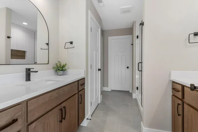 a spacious bathroom with a granite countertop sink and a mirror