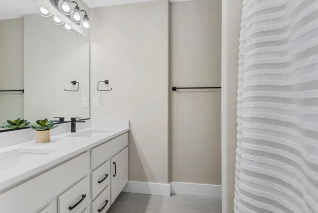a bathroom with a sink a large mirror and shower