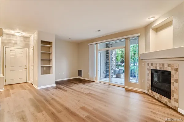 a view of an empty room with window and fire place