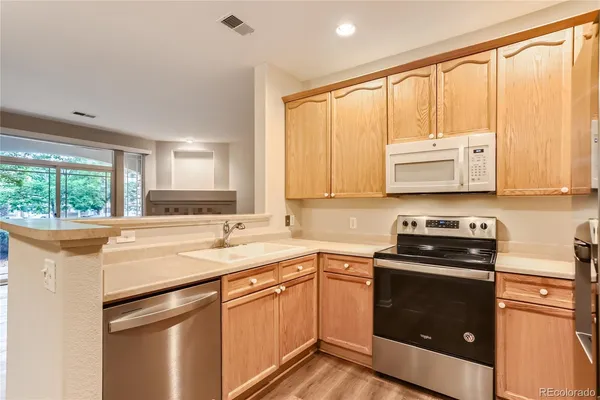 a kitchen with granite countertop a refrigerator and a stove top oven