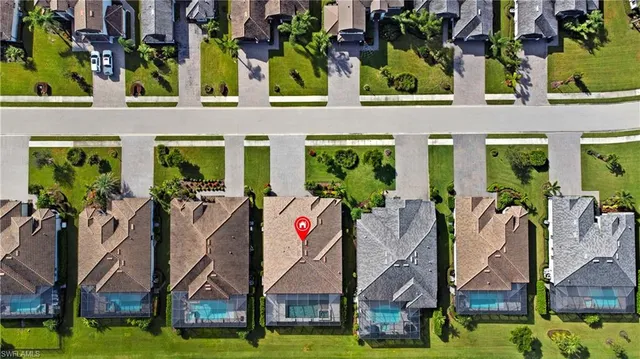 an aerial view of a residential houses with yard