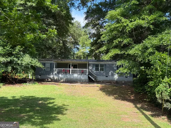 a front view of a house with yard porch and tree