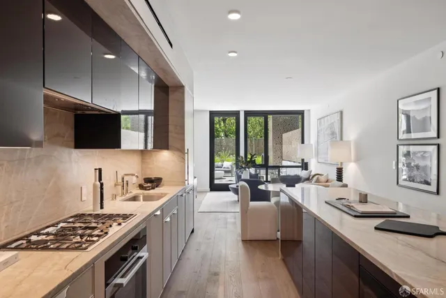 a large kitchen with stainless steel appliances lots of counter space and a sink
