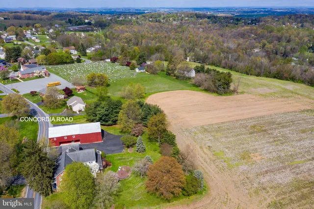 an aerial view of a houses with a yard and lake view