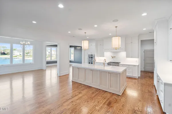 a view of a hallway with wooden floor and a kitchen