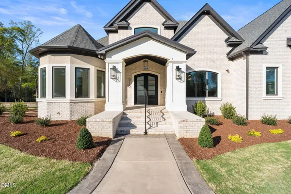 a front view of a house with a garden and yard