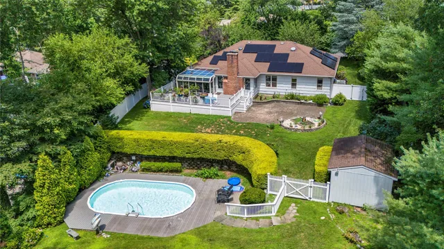 an aerial view of a house with swimming pool and garden