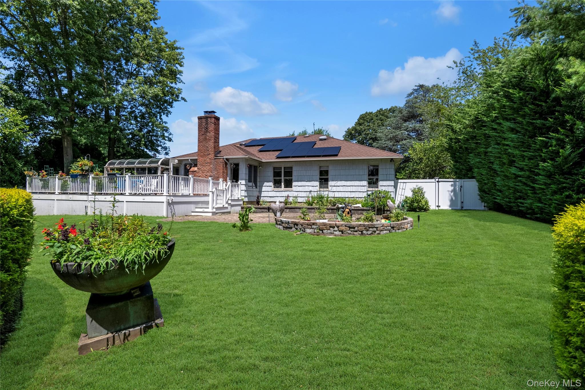 17 Melody Lane Bayville, NY 11709 - Photo 2 of 26 a front view of a house with a yard table and chairs