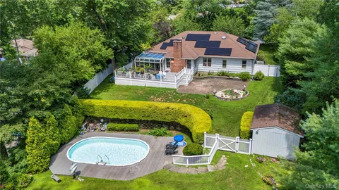 an aerial view of a house with swimming pool and garden
