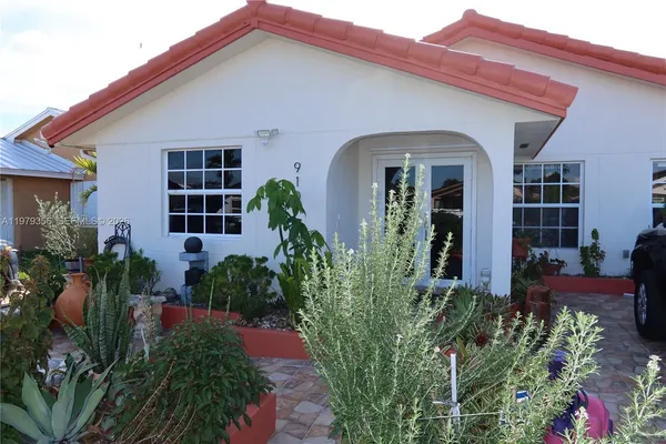 front view of a house with potted plants