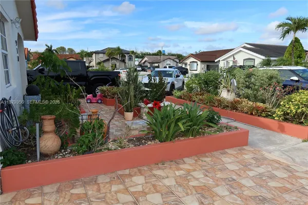 a view of a patio with table and chairs potted plants