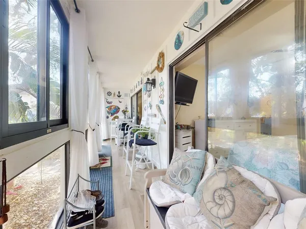 a living room with furniture a flat screen tv and a window