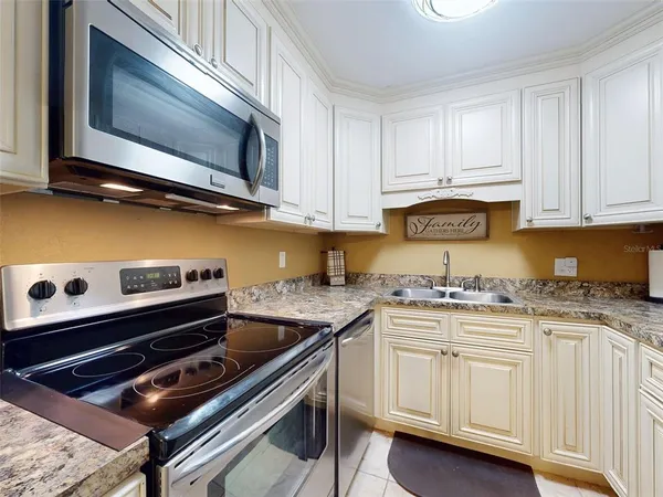 a kitchen with stainless steel appliances granite countertop a refrigerator and a stove top oven