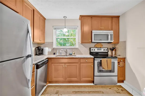 a kitchen with stainless steel appliances granite countertop a stove a sink and a microwave