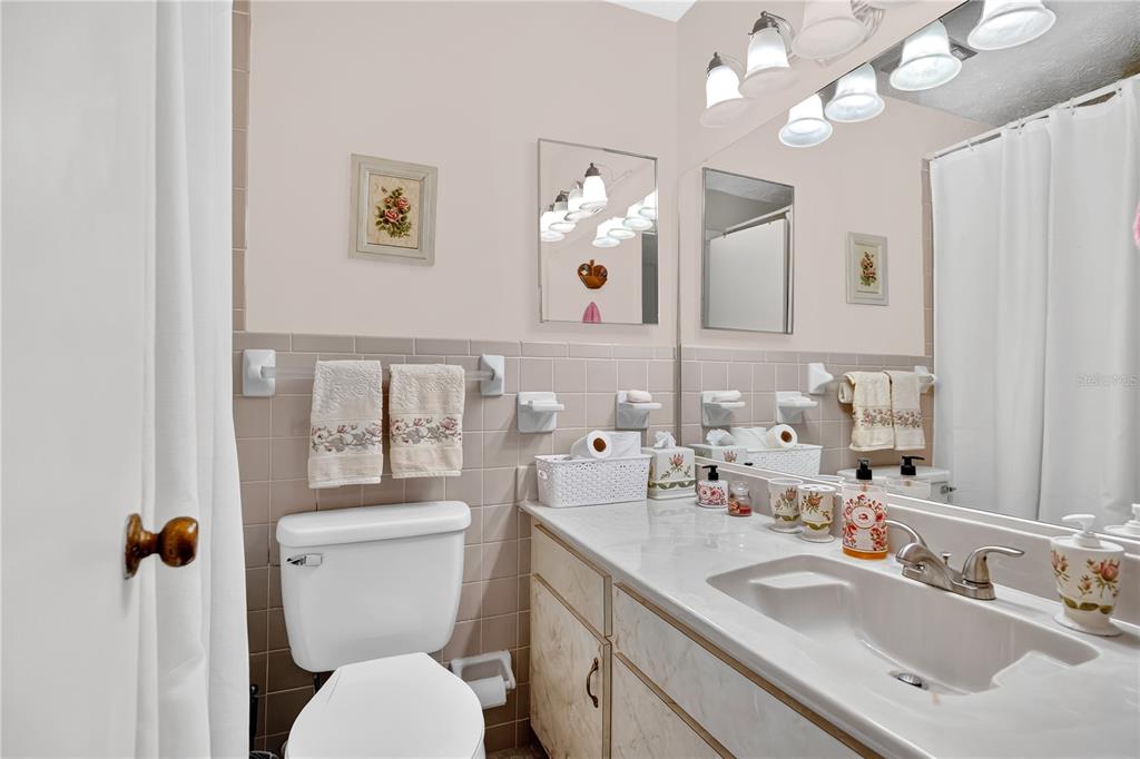 4262 Lake Underhill Road, Unit 9C7 Orlando, FL 32803 - Photo 16 of 22 a bathroom with a toilet a sink and mirror