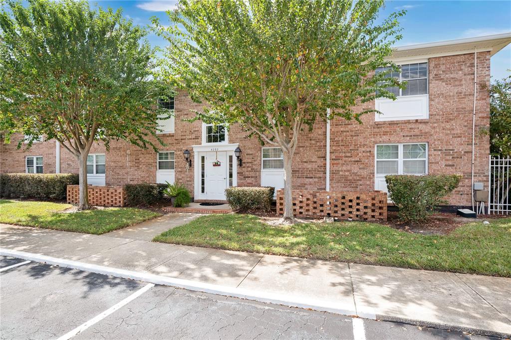 4262 Lake Underhill Road, Unit 9C7 Orlando, FL 32803 - Photo 2 of 22 a front view of a house with a yard and a garage