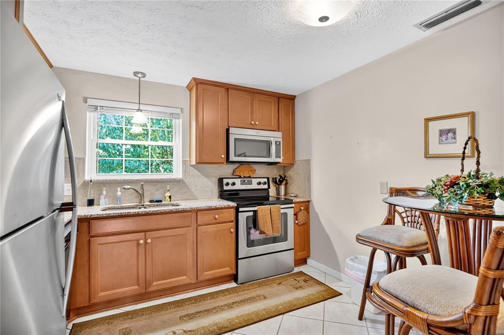 4262 Lake Underhill Road, Unit 9C7 Orlando, FL 32803 - Photo 9 of 22 a kitchen with a sink stove and microwave