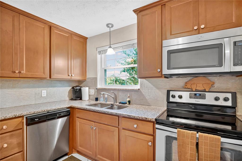 4262 Lake Underhill Road, Unit 9C7 Orlando, FL 32803 - Photo 10 of 22 a kitchen with stainless steel appliances wooden cabinets and a stove top oven