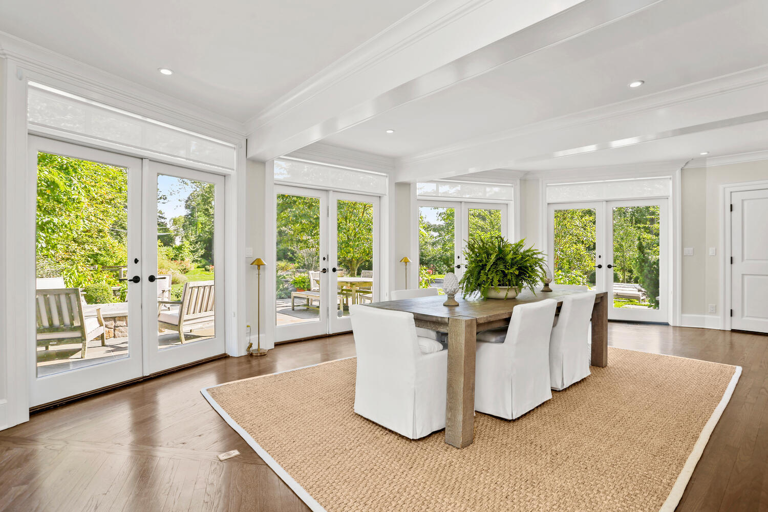 43 Contentment Island Road Darien, CT 06820 - Photo 14 of 59 a living room with large windows a dining table and chairs