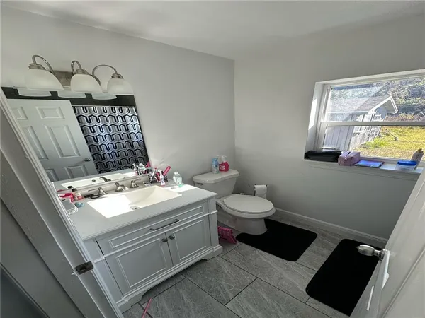 a bathroom with a sink mirror vanity and toilet