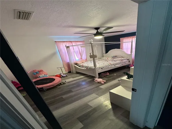 a bedroom with bed and wooden floor