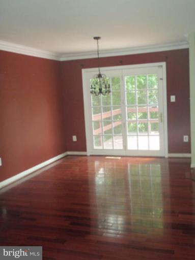 1803 Post Oak Trail Reston, VA 20191 - Photo 3 of 17 a view of an empty room with wooden floor and a window