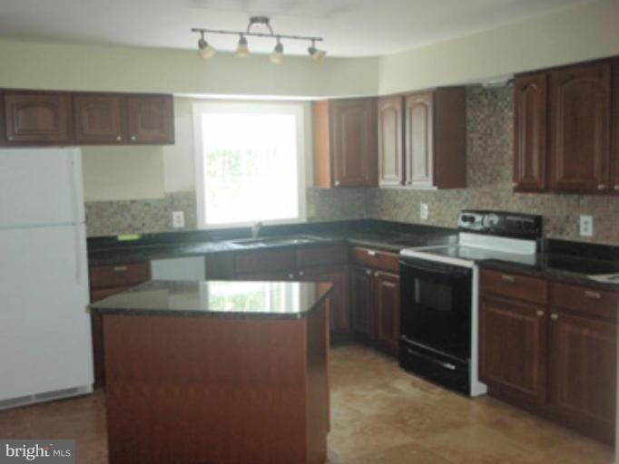 1803 Post Oak Trail Reston, VA 20191 - Photo 4 of 17 a kitchen with granite countertop a sink stainless steel appliances and cabinets