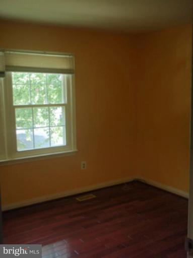 1803 Post Oak Trail Reston, VA 20191 - Photo 7 of 17 a view of an empty room with wooden floor and a window