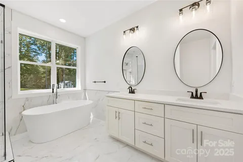 a bathroom with a tub sink and mirror